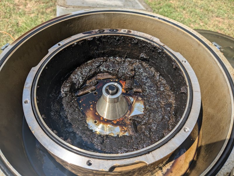 Opened centrifuge bowl showing dark sludge and captured contaminants